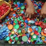 person hands on assorted color plastic lid lot
